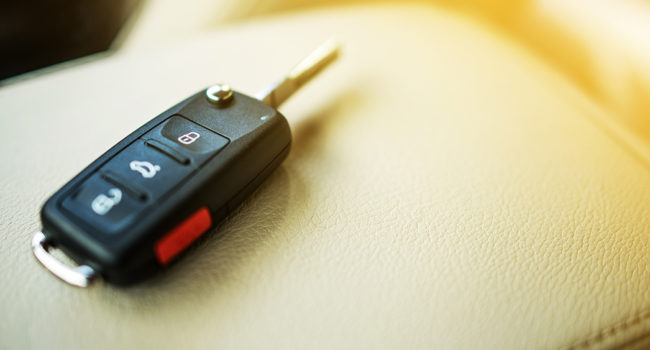 Brand New Car Keys on Leather Closeup. Cars Industry Concept.